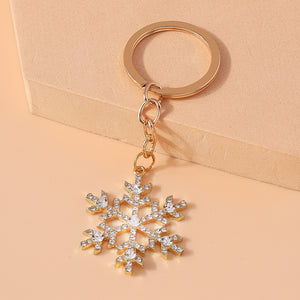 Crystal snowflake keychain leaning against beige block – side angle