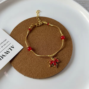 Gold bracelet with red beads on a brown circular pad