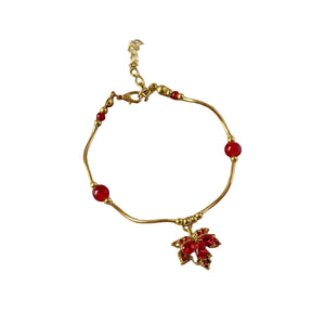 Gold bracelet with red beads on a brown circular pad
