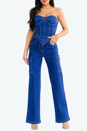 Woman wearing a blue denim jumpsuit on a white background