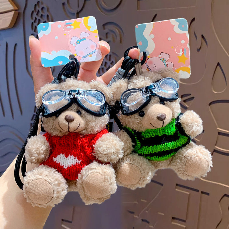 Red and green sweater goggle bear plush keychains held in hand – pair shot