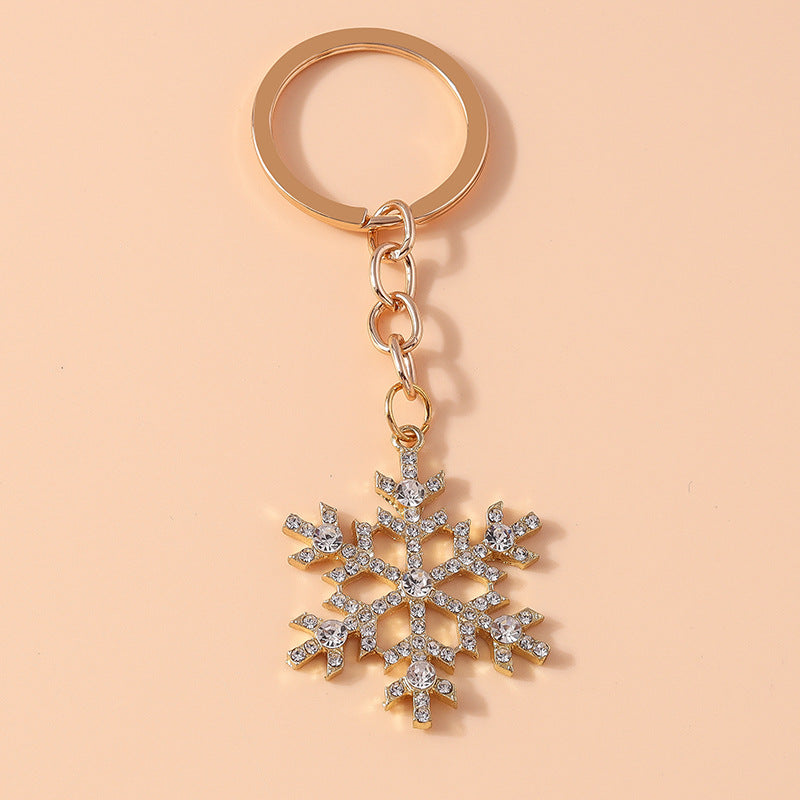 Gold crystal snowflake keychain on peach background – product shot