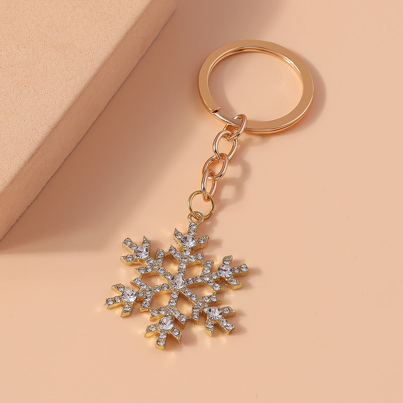 Crystal snowflake keychain flat lay on peach surface – angled view